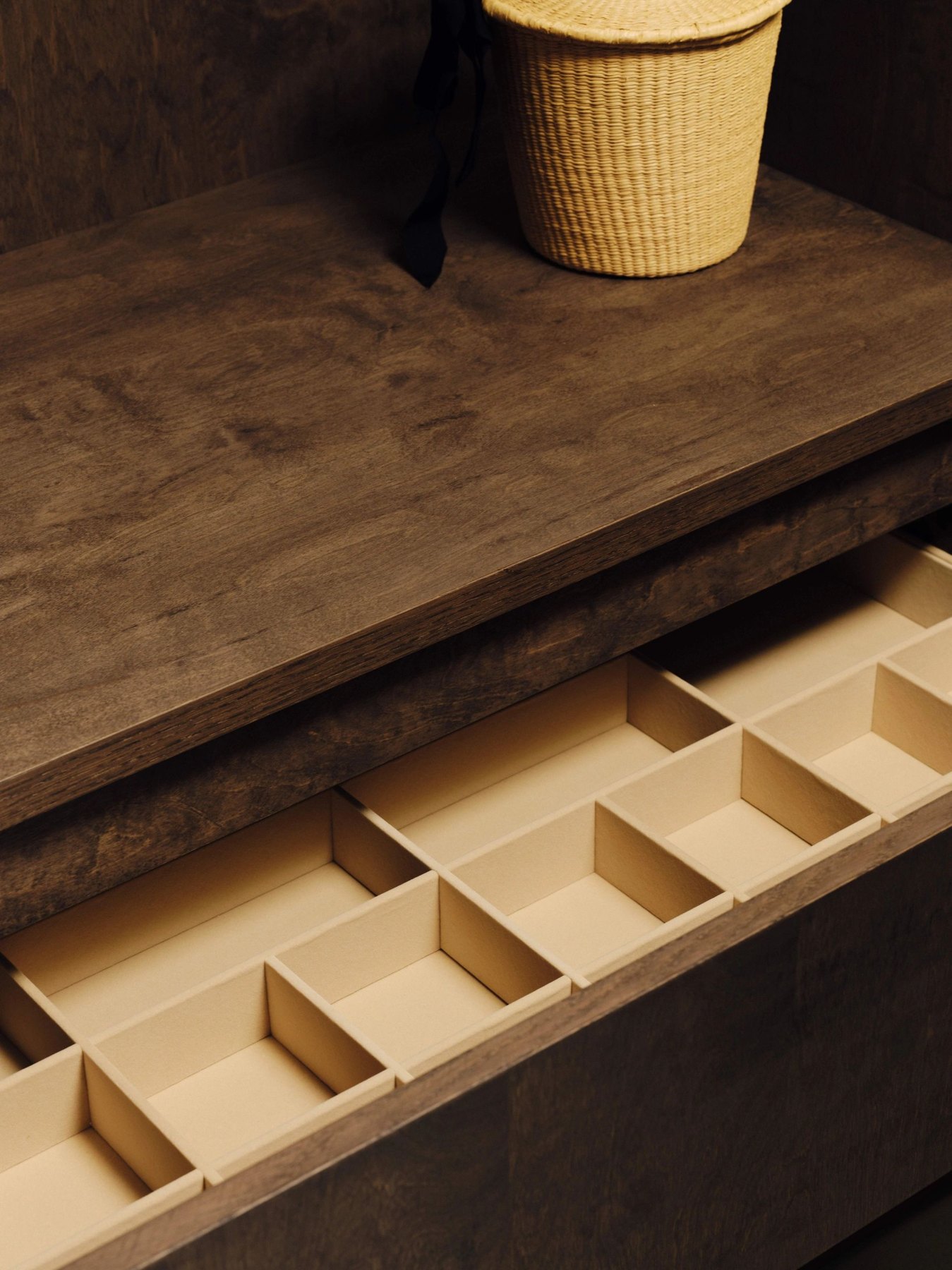 A precisely divided timber drawer beneath a stone worktop